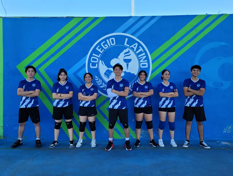 Equipo de voleibol de Bachillerato de Colegio Latino posando frente a un mural institucional