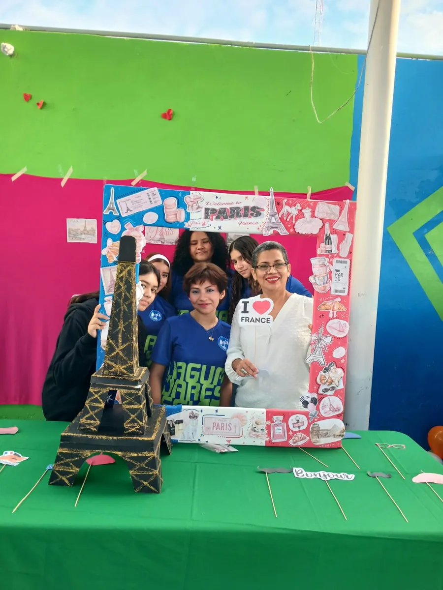 Estudiantes y profesora de Colegio Latino posando en un fotomatón con temática de París durante una actividad de francés