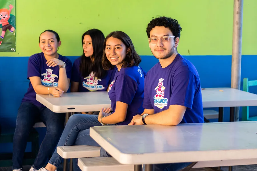 Estudiantes de Bachillerato de Colegio Latino con playeras de la Fundación Siiniko'ob en una actividad escolar