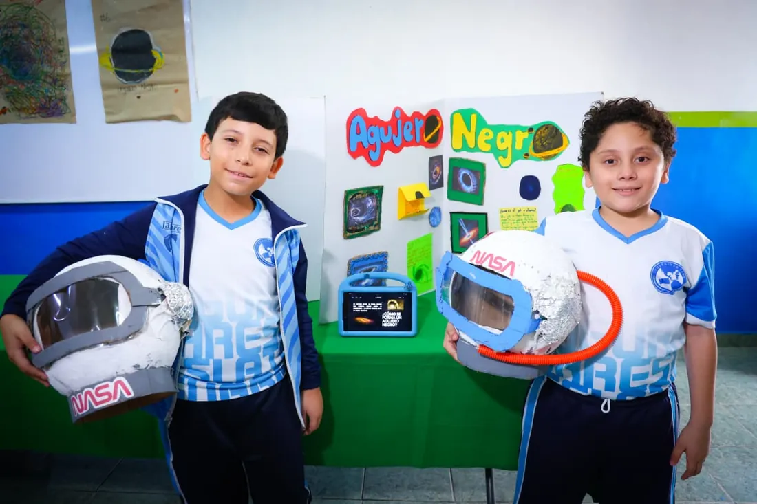 Estudiantes de Primaria de Colegio Latino presentando un proyecto con cartel expositivo